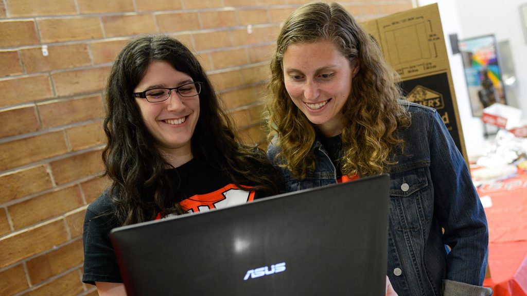Two female math students look at a laptop