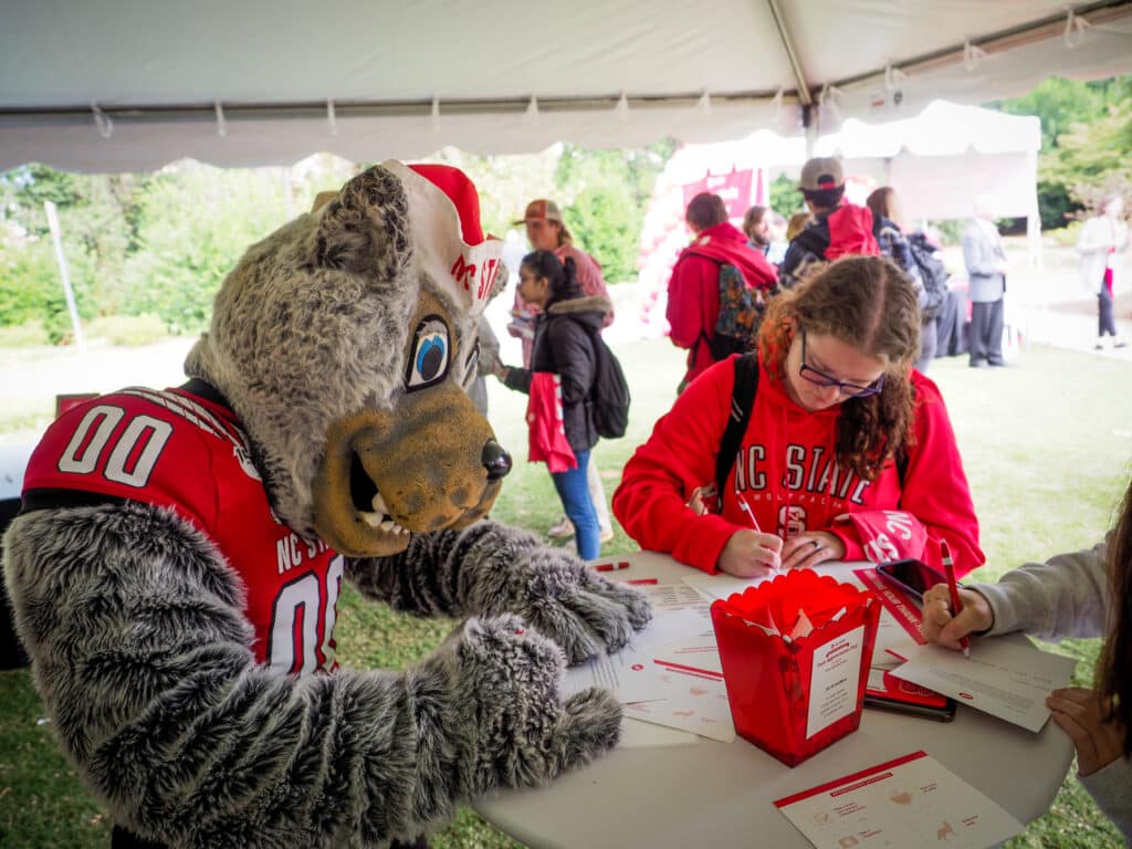 Mr. Wuf and a student fill out a form in Talley